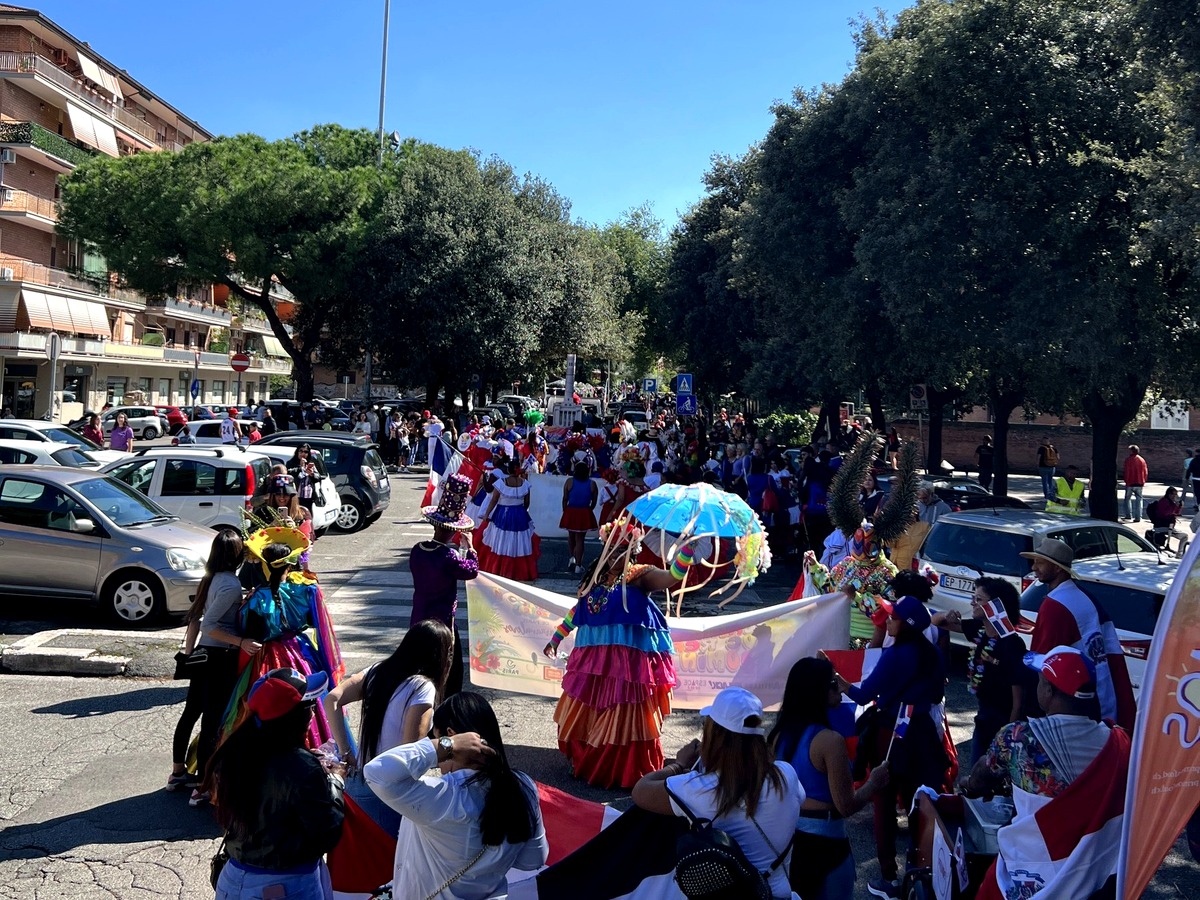 Community members gathered around Dominican flags during a cultural parade celebration.